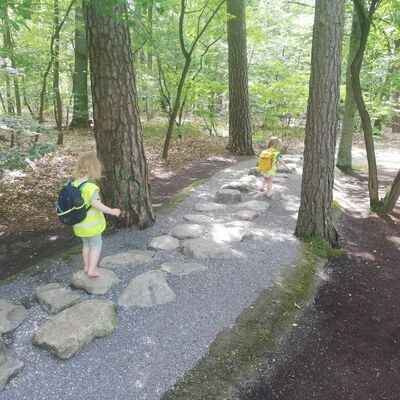 Bild vergr&ouml;&szlig;ern: Kita Spielhaus - Kinder balancieren im Barfu&szlig;park von Stein zu Stein