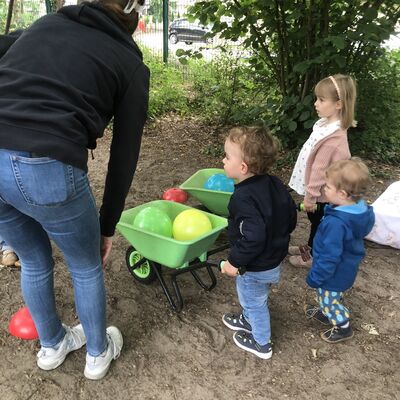 Bild vergr&ouml;&szlig;ern: drei Kinder und ein Erwachsener beim Schubkarrenlauf