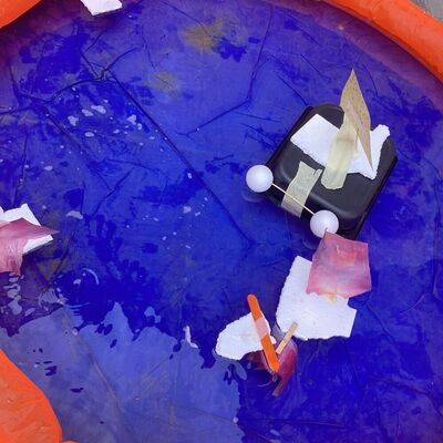 Bild vergr&ouml;&szlig;ern: In einem mit Wasser bef&uuml;llten kleinem Planschbecken befinden sich selbst gebastelte Boote, die mit Wind angetrieben werden.