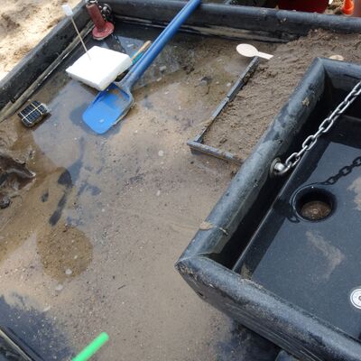 Bild vergr&ouml;&szlig;ern: Experimente in einem mit Sand und Wasser bef&uuml;llten Becken - Energie aus Wasserbewegung