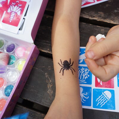 Bild vergr&ouml;&szlig;ern: Ein Spinnen-Glitzertattoo auf einem Kinderarm.