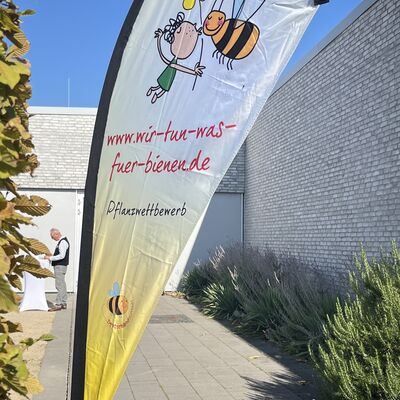 Bild vergr&ouml;&szlig;ern: Beim Veranstaltungsort "G&auml;rten der Welt" steht eine Werbefahne mit Logoaufdruck des Pflanzwettbewerbes.