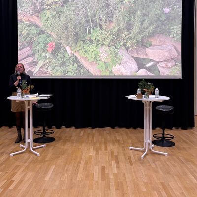 Bild vergr&ouml;&szlig;ern: Im B&uuml;rgersaal des Rathauses werden auf einer Leinwand von Frau Reich (Lokale Agenda und Umweltschutz bei der Gemeinde Kleinmachnow) Fotos gezeigt und erl&auml;utert.