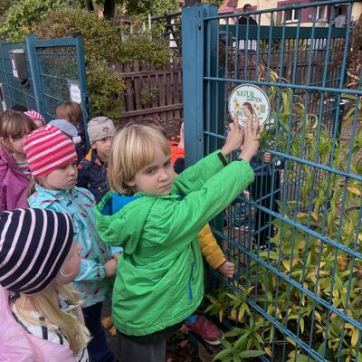 Bild vergr&ouml;&szlig;ern: Die Kinder bringen Plakette am Eingang der Kita an.