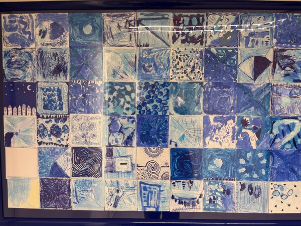 Das Kunstwerk aus vielen einzeln gestalteten blauen Bildern der Kinder.