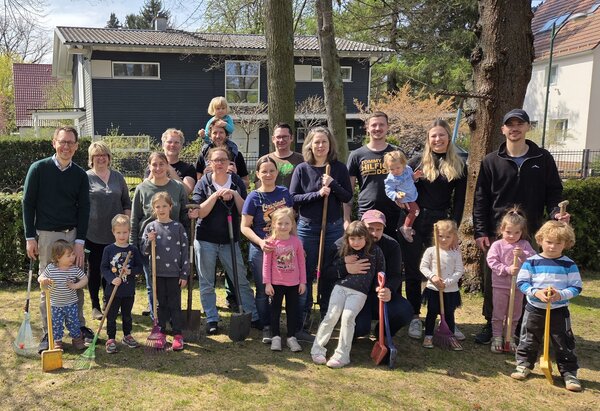Gruppenfoto nach dem Arbeitseinsatz im Kita-Garten mit Eltern, Kindern und Team der Kita Waldh&auml;uschen