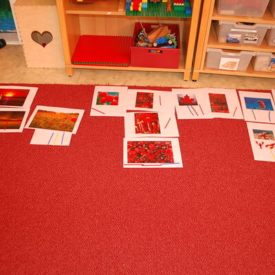 Die ausgedruckten Bilder wurden auf einem roten Teppich gelegt. Dort hatten die Kinder die M&ouml;glichkeit, mit einem St&auml;bchen ihren Wunschnamen f&uuml;r den Gruppennamen zu kennzeichnen.