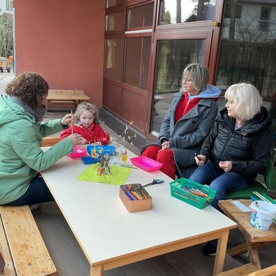 Bild vergr&ouml;&szlig;ern: ein Kind und drei Erwachsene sitzen am Tisch