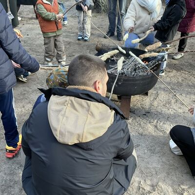 Bild vergr&ouml;&szlig;ern: mehrere Personen mit Stockbrot am Lagerfeuer