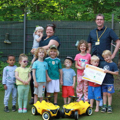 Gruppenbild Spenden&uuml;bergabe - Mehrere Kinder und eine p&auml;dagogische Fachkraft der Kita Am Seeberg nahmen mit viel Freude die Spende von der DHL Group, Herrn Dennis Joswiak. (v. l. n. r.) entgegen.