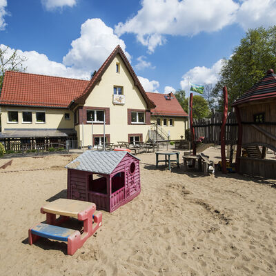 Bild vergrößern: Kita Pitti-Platsch Frontansicht Haus und Spielplatz